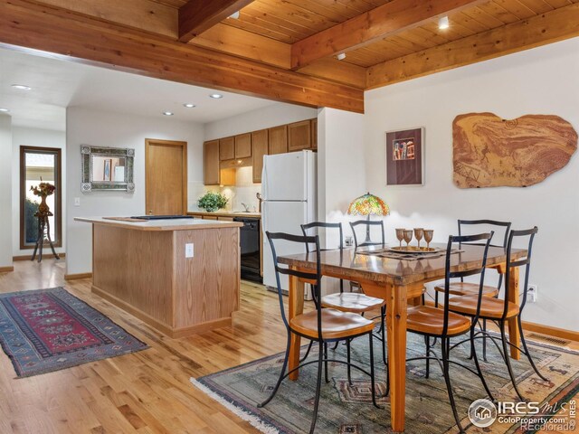 dining room featuring beam ceiling, wood ceiling, and light wood-style floors