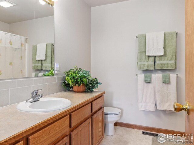 bathroom featuring tile patterned flooring, visible vents, toilet, decorative backsplash, and vanity