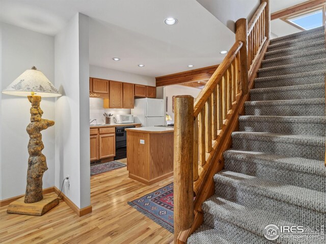 kitchen with white appliances, baseboards, light wood finished floors, recessed lighting, and light countertops