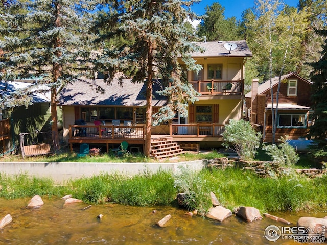 back of house with a deck with water view