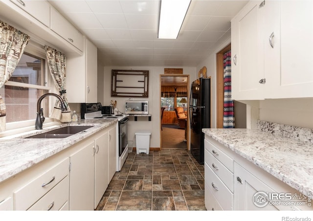2392 W US Highway 34, Drake, CO 80515 - kitchen with electric stove, a sink, freestanding refrigerator, stainless steel microwave, and white cabinetry