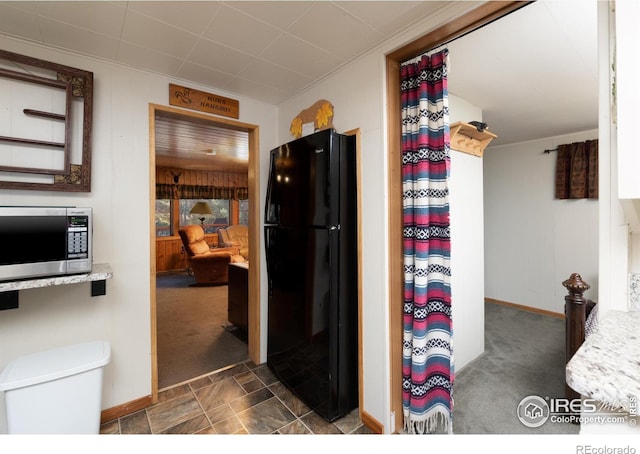 kitchen with dark carpet, crown molding, and black refrigerator