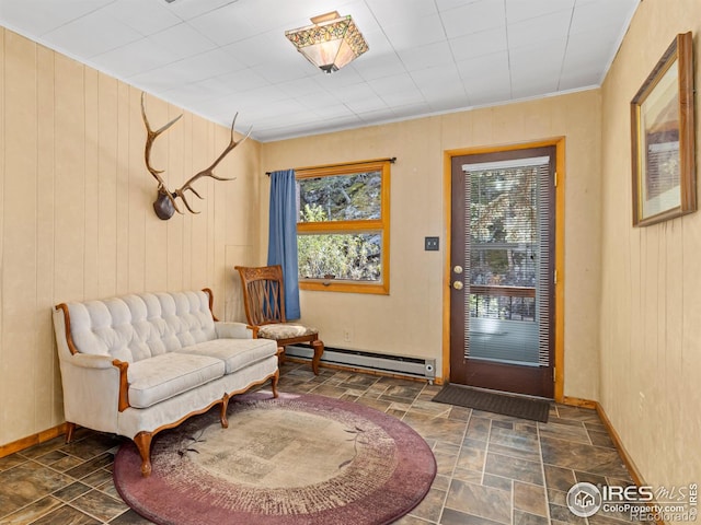 entrance foyer featuring wood walls and a baseboard heating unit