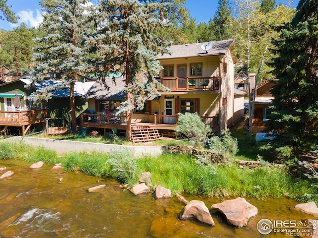 exterior space featuring a deck with water view