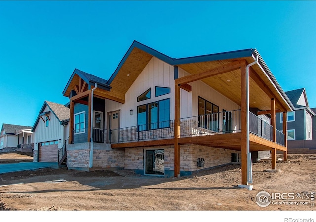 view of property exterior featuring stone siding, board and batten siding, and a garage