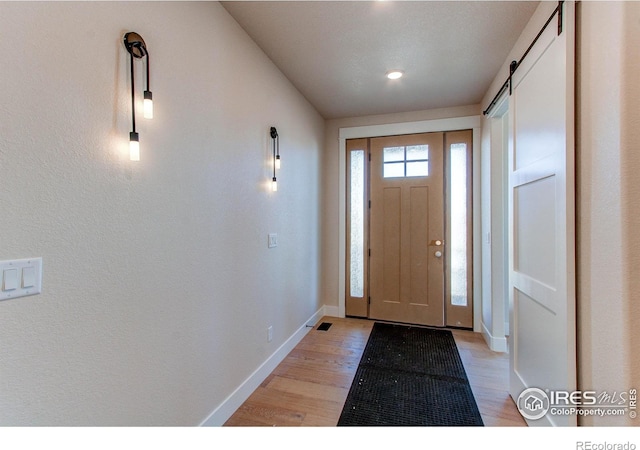 entryway featuring a barn door and light wood-type flooring