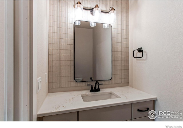 bathroom featuring vanity and a textured wall