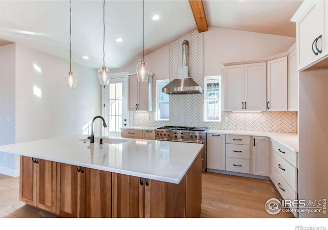 kitchen featuring light wood-style flooring, stainless steel range, a sink, lofted ceiling with beams, and backsplash