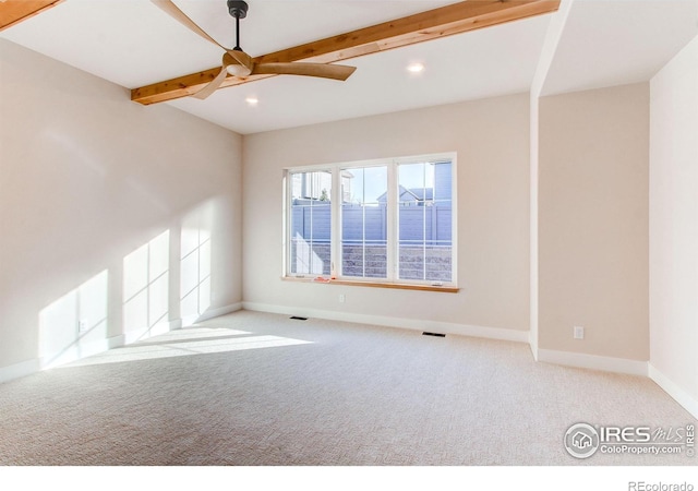 carpeted spare room featuring ceiling fan and beam ceiling