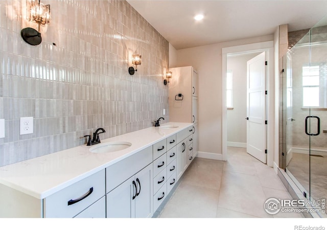 bathroom featuring an enclosed shower, vanity, tile walls, and tile patterned floors