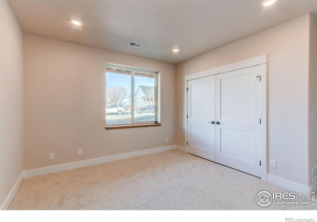 unfurnished bedroom featuring visible vents, baseboards, and carpet flooring