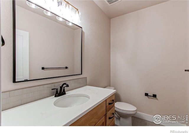 half bathroom with visible vents, toilet, and vanity