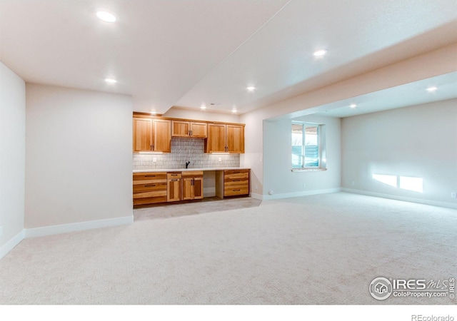 kitchen with decorative backsplash, sink, and light carpet