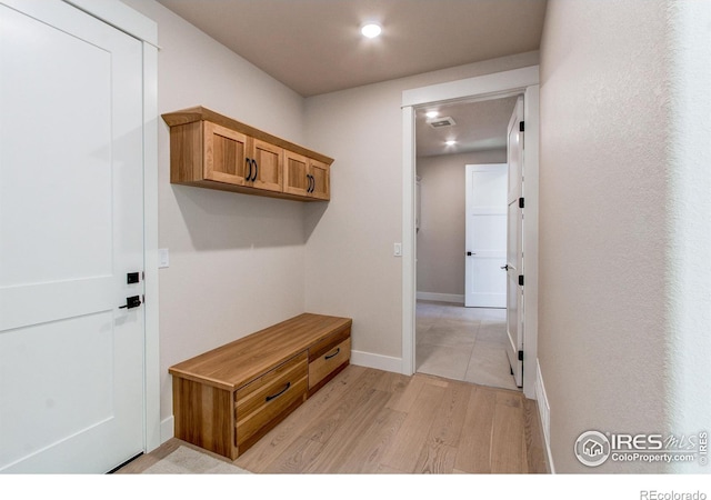 mudroom featuring visible vents, baseboards, and light wood finished floors