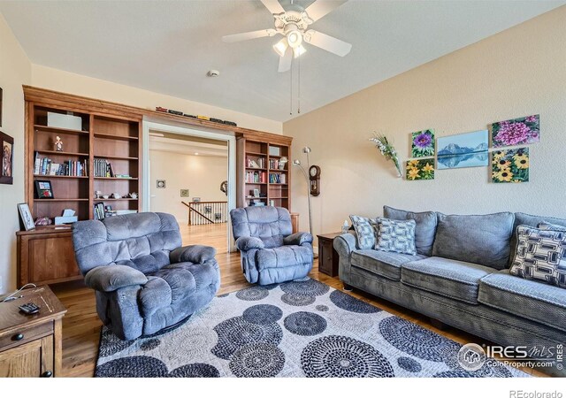 living room featuring light hardwood / wood-style floors and ceiling fan