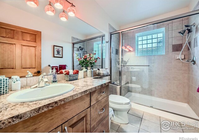 bathroom featuring tile patterned floors, vanity, walk in shower, and toilet