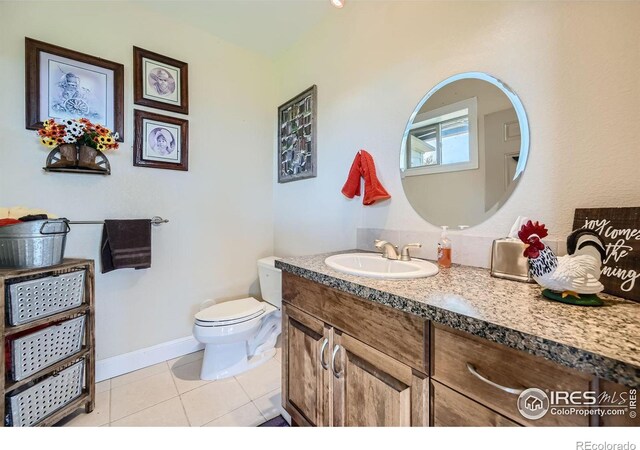 bathroom featuring tile patterned flooring, vanity, and toilet