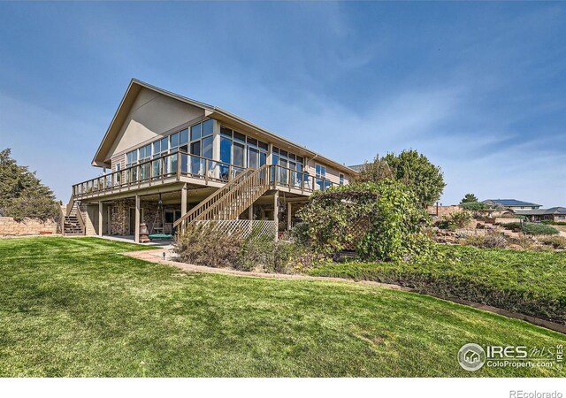 rear view of house featuring a yard and a wooden deck