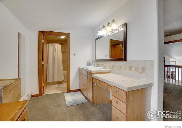 bathroom with vanity, decorative backsplash, baseboard heating, and walk in shower