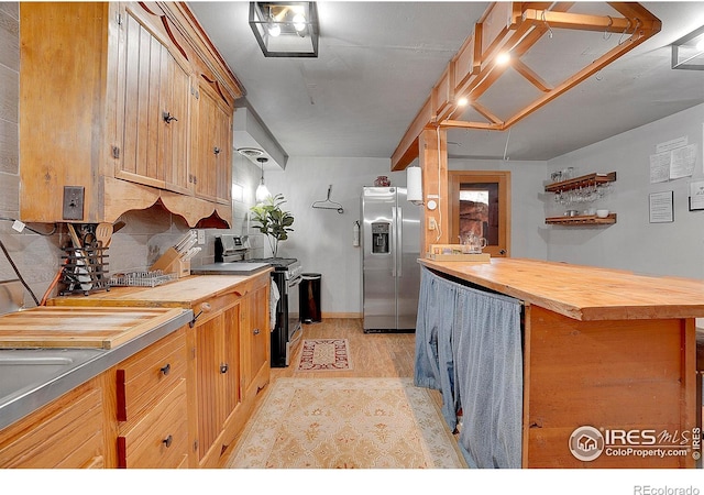 kitchen with butcher block countertops, backsplash, and appliances with stainless steel finishes