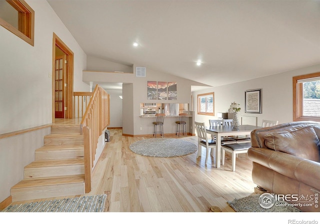 living room with light hardwood / wood-style flooring, plenty of natural light, and lofted ceiling