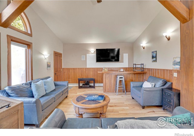 living room featuring beamed ceiling, light wood-type flooring, and high vaulted ceiling