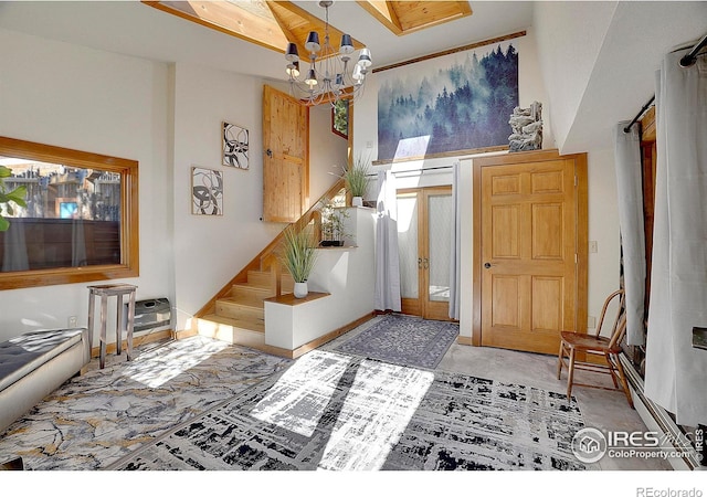 carpeted entrance foyer featuring a high ceiling, an inviting chandelier, and french doors