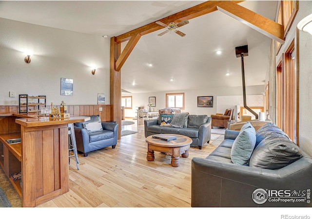 living room with vaulted ceiling with beams, ceiling fan, and light hardwood / wood-style flooring