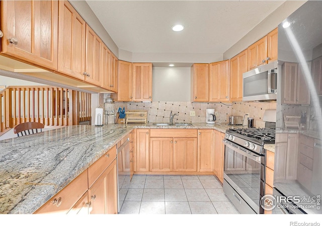 kitchen featuring light stone countertops, light brown cabinets, stainless steel appliances, and decorative backsplash