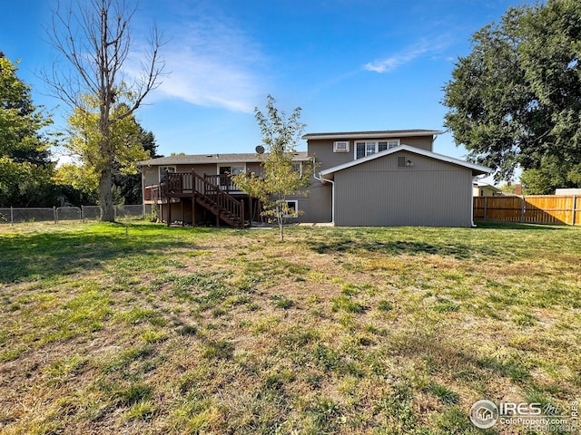 view of yard with a wooden deck, a fenced backyard, and stairway