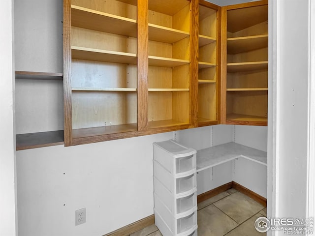 unfurnished office featuring tile patterned flooring and baseboards