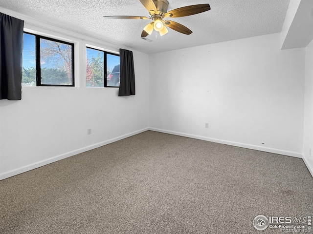 empty room featuring ceiling fan, a textured ceiling, and carpet