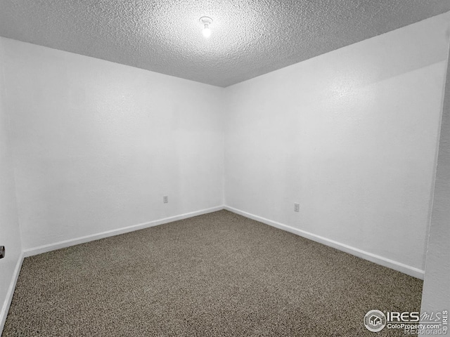 carpeted spare room with baseboards and a textured ceiling
