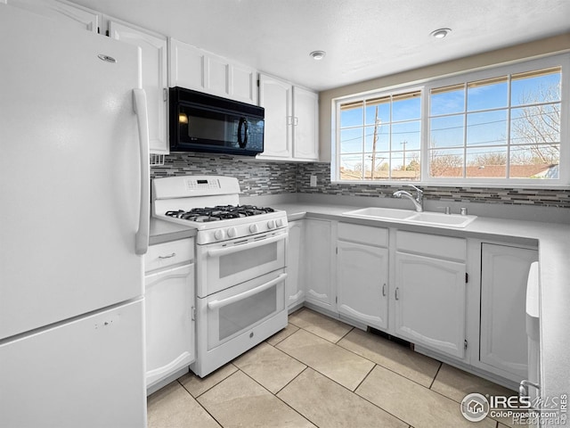 kitchen featuring white cabinets, backsplash, light tile patterned floors, a sink, and white appliances