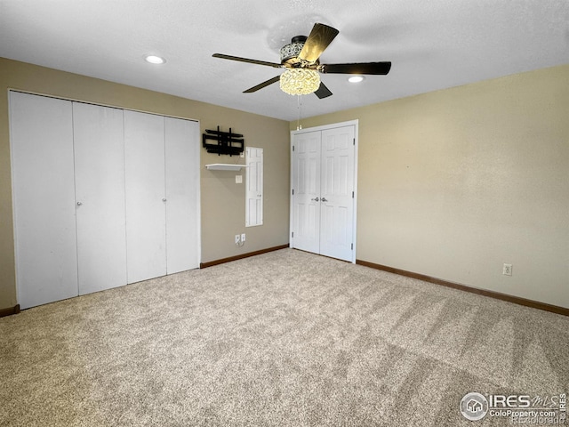 unfurnished bedroom featuring carpet, multiple closets, and baseboards