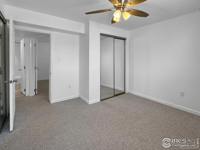 unfurnished bedroom featuring carpet, a textured ceiling, and a closet