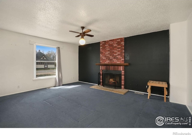 unfurnished living room with a fireplace, ceiling fan, carpet flooring, and a textured ceiling