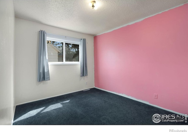 carpeted spare room with a textured ceiling