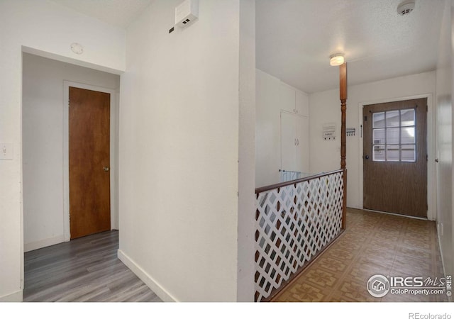 foyer entrance with hardwood / wood-style floors and a textured ceiling