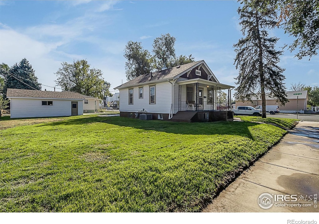 view of side of home featuring a yard, central AC, a porch, and an outdoor structure