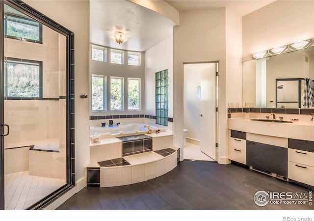 full bathroom with hardwood / wood-style floors, vanity, toilet, and shower with separate bathtub