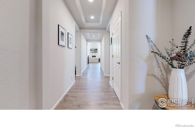 corridor featuring a raised ceiling and light hardwood / wood-style flooring