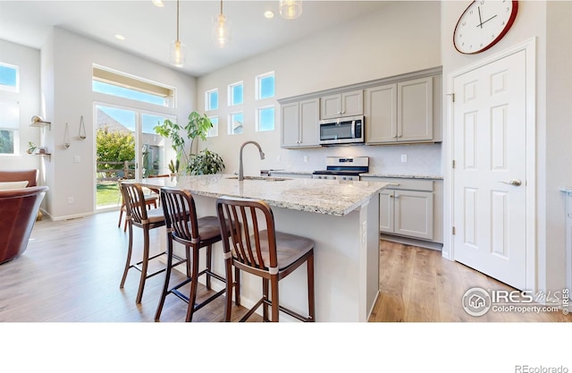 kitchen featuring white range, light hardwood / wood-style floors, sink, and gray cabinetry