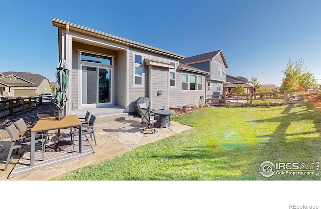 back of property featuring a lawn and a patio area