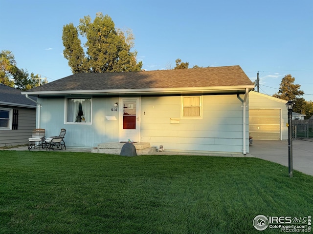 rear view of house featuring a yard and a garage