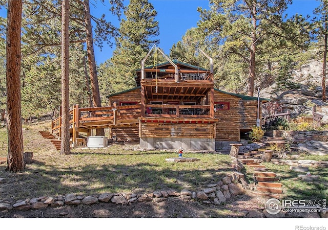 back of property featuring a yard and a wooden deck