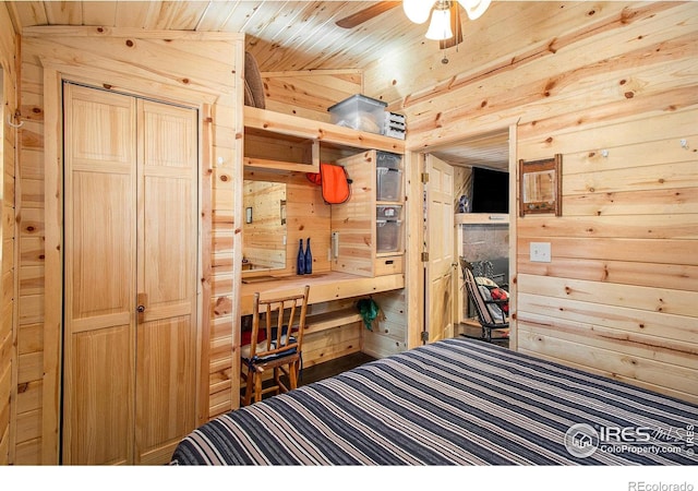 bedroom with lofted ceiling, wood walls, a closet, and wooden ceiling