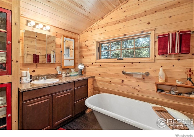 bathroom with vanity, lofted ceiling, wooden walls, and a tub to relax in