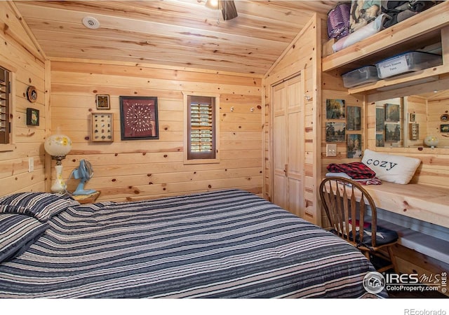 bedroom featuring lofted ceiling, wood walls, a closet, and wood ceiling