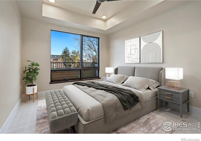 bedroom with ceiling fan and a tray ceiling